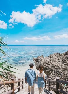 海へ続く階段を歩く男女と美しい海岸風景